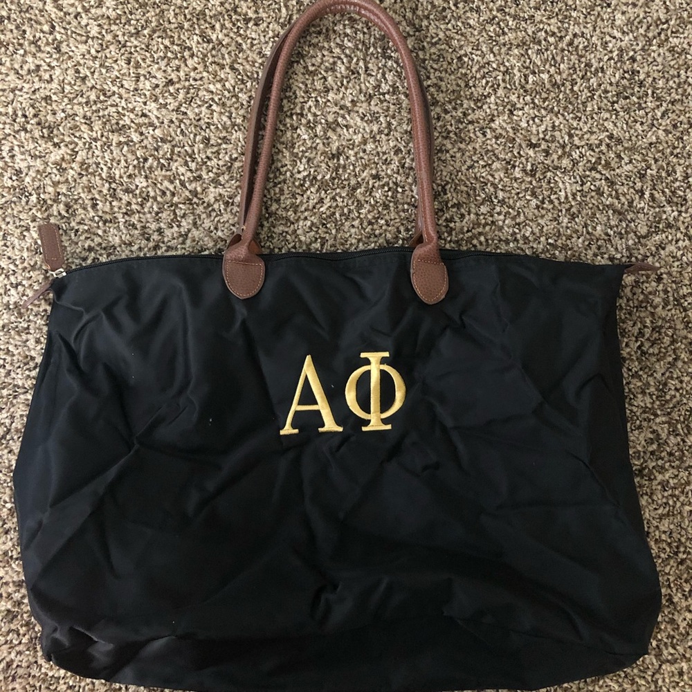 Alpha Phi black tote bag with brown handles and gold embroidery